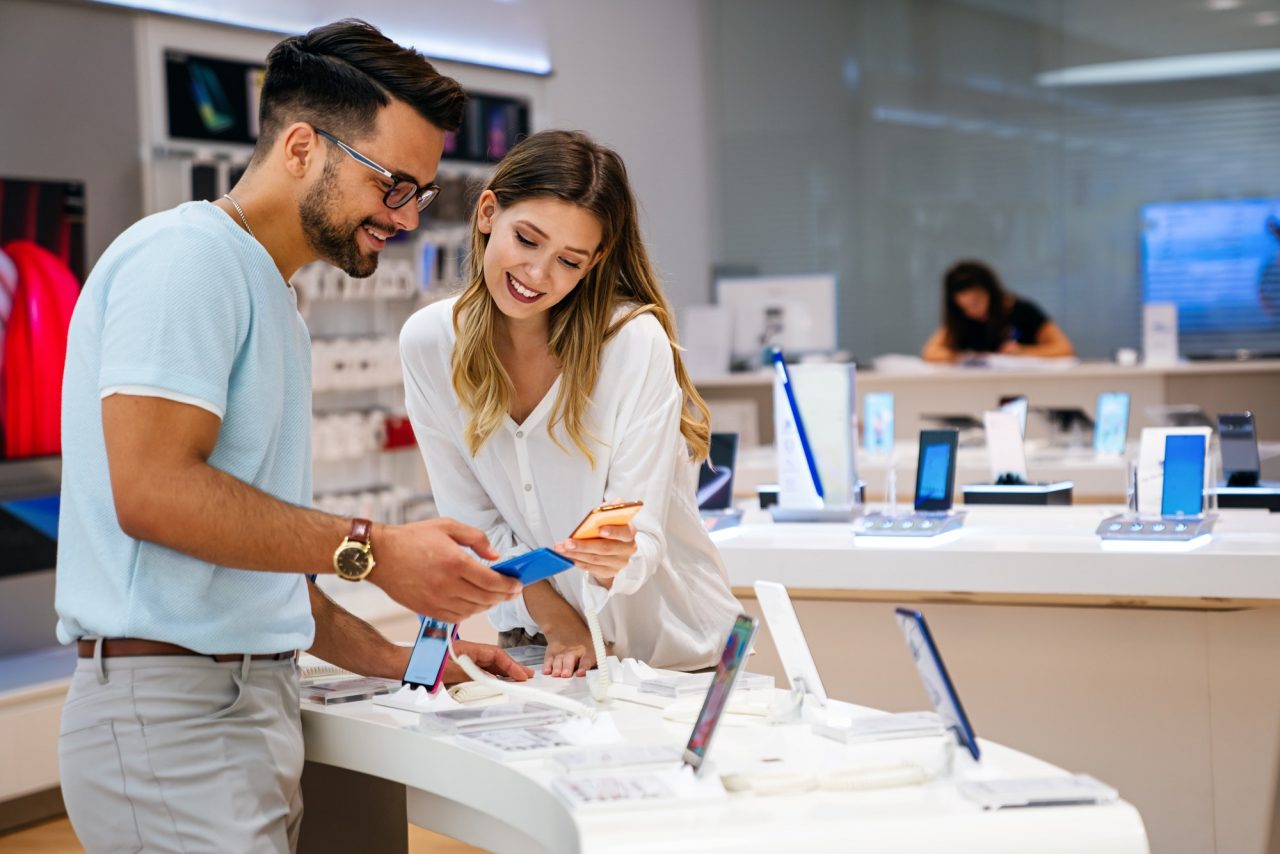 Kauf eines neuen digitalen Geräts Glückliches Paar kauft ein Smartphone im Geschäft